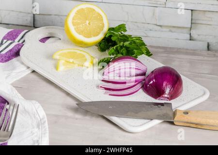 Sliced red onion, lemon and parsley leaves Stock Photo