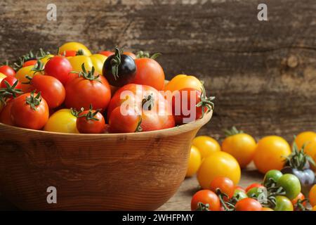 Wooden bowl with fresh vine ripened heirloom tomatoes from farmers market Stock Photo