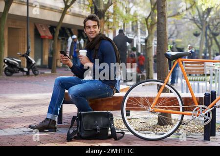 Man, smartphone and coffee and bike for travel and carbon footprint, communication and cycling outdoor. Eco friendly transport, using phone for Stock Photo