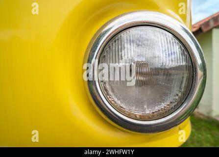 Round headlight of an old yellow car Stock Photo