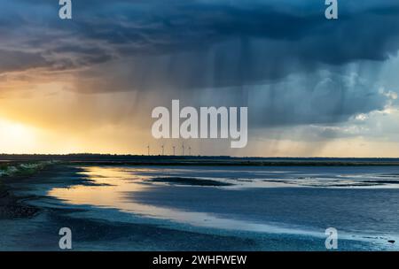 Dramatic rain storm over lake at sunset Stock Photo