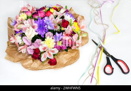 Bouquet of natural bright flowers and scissors on a white background Stock Photo
