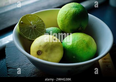 Lime green and yellow in a plastic container on the shelves ready to be made into cooking ingredients. Stock Photo