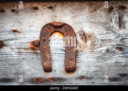 Old horseshoe hanging on wooden wall Stock Photo