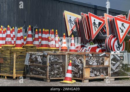 Traffic cones or pylons and signs for road construction sites on an outdoor storage area, selected focus Stock Photo