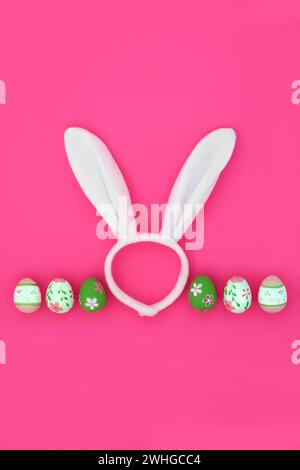 Easter bunny ears fun headband with decorated eggs on vivid pink background. Abstract design for the holiday season. Stock Photo