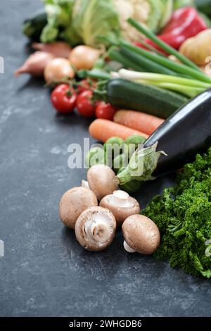 Lot of fresh vegetables of different varieties on a dark gray slate surface, healthy food concept for a balanced diet, copy spac Stock Photo