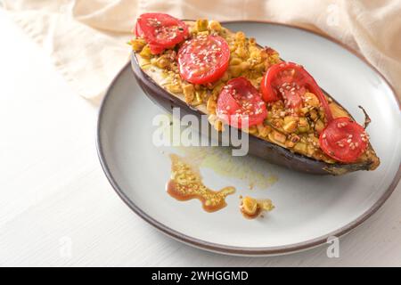 Healthy vegetarian low carb meal, baked eggplant with turmeric, ginger, onions, tomatoes and sesame seed on a plate on a white w Stock Photo