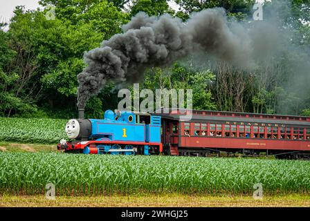 View of Thomas the Train Pulling Passenger Cars Blowing Smoke and Steam Stock Photo