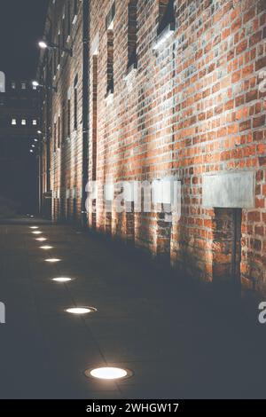 An old brick building illuminated by bright lamps at night Stock Photo