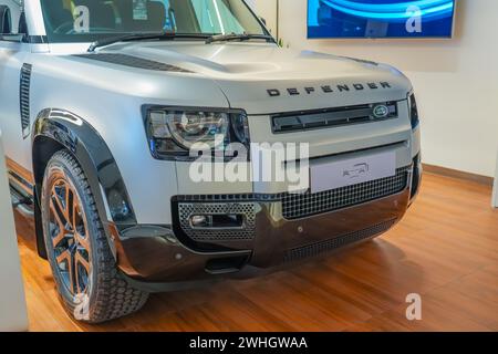 Land Rover Defender silver gray in the showroom on the shop showcase exhibition of an official dealer. Thailand, Bangkok 21 december 2023. Stock Photo