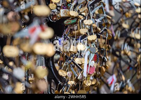 Jelgava, Latvia - January. 14. 2023:  Many heart-shaped padlocks on metal grates in the park. Concepts of wedding tradition or romance. Stock Photo