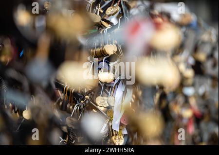 Jelgava, Latvia - January. 14. 2023:  Many heart-shaped padlocks on metal grates in the park. Concepts of wedding tradition or romance. Stock Photo