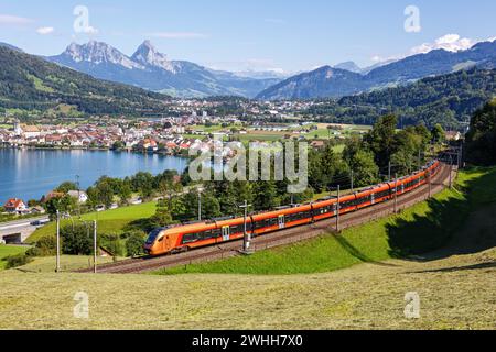 Arth, Switzerland - August 10, 2023: Railway Passenger Train Type Stadler Flirt Of The Southeast Railway At The Mountain Grosser Mythen Am Zugersee In Stock Photo