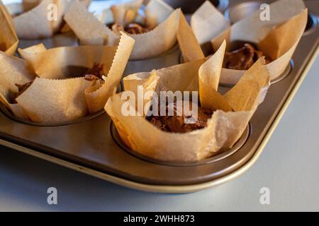 Chocolate cake batter in a paper wrapper in a baking dish Stock Photo