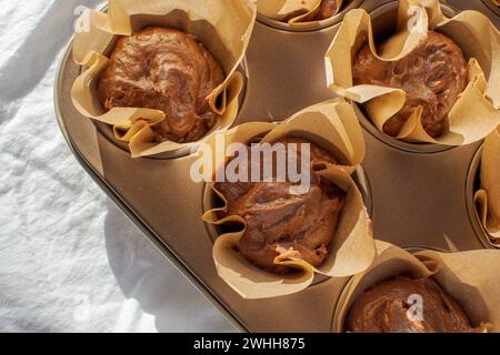 Freshly made chocolate cupcake dough in a white cotton-based baking dish Stock Photo