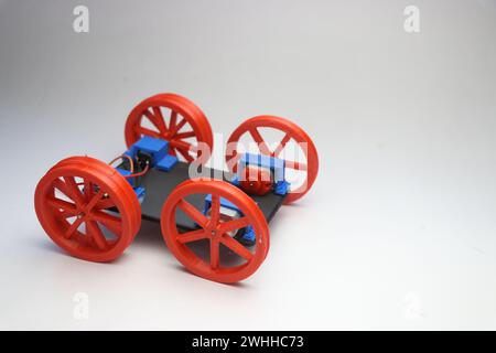 Model of an assembled wheel movement for a robotic car on a white background. Building electronic hobby projects concept Stock Photo