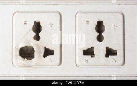 close-up of old electrical power sockets with melted and deformed plastic around the socket openings, overheated due to loose connections, overloaded Stock Photo