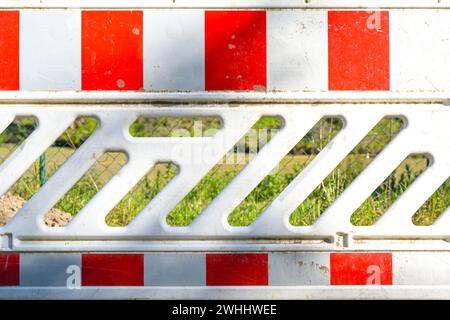 Red white traffic barrier as a safety measure for earthworks on a sunny day, copy space Stock Photo
