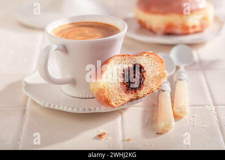 Delicious and fresh doughnuts served with coffee. Donuts with jam and sweet topping. Stock Photo