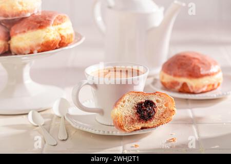 Traditionally and homemade doughnuts served with coffee. Donuts with jam and sweet topping. Stock Photo