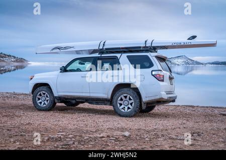 Loveland, CO, USA - February 6, 2024: Toyota 4Runner SUV with Liteboat rowing shell on roof racks on a shore of Carter Lake in northern Colorado at wi Stock Photo