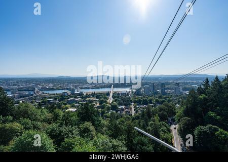 A photo of the Portland Aerial Tram with the Portland Skyline and Mt. Hood in the background on a clear sunny summer day. Stock Photo