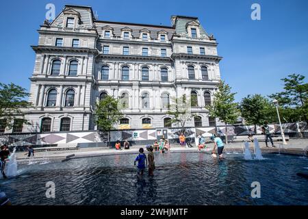 Montreal, Canada - aug 09 2023 - Children play in the waters of the Vauquelin fountain in downtown Montreal during the summer. Canada Stock Photo