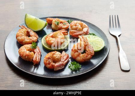 Shrimps. Cooked shrimp with lime on a blue plate, on a rustic background Stock Photo
