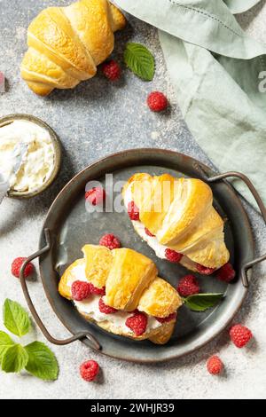 Healthy food dessert concept, french pastry. Tasty freshly baked croissants with cream cheese and raspberry on a stone backgroun Stock Photo