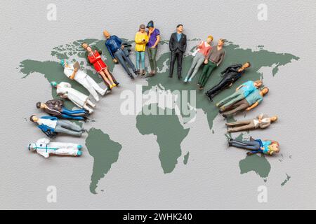Miniature people standing on the world map with gray background Stock Photo