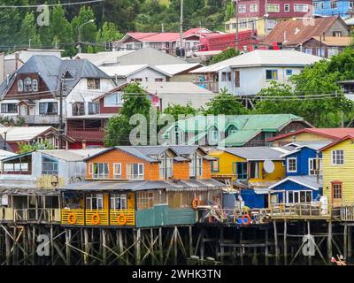 Houses built on stilts, known locally as Palafitos, lining the waters edge in Castro, capital of the Island of Chiloe in Chile Stock Photo