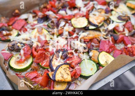 Oven-baked vegetables with eggplant, zucchini, bell pepper, onions and parmesan cheese on a baking tray, copy space, selected fo Stock Photo