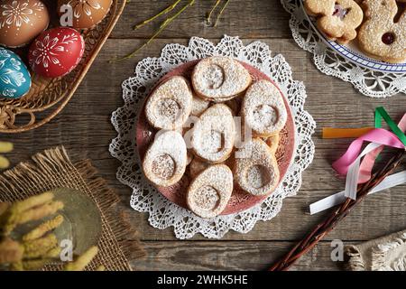 Homemade Linzer cookies in the shape of eggs and animals, with Easter decoration in the background Stock Photo