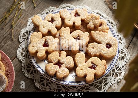 Linzer cookies in the shape of Easter bunnies, chicken and four leaf clovers filled with marmalade and dusted with sugar Stock Photo