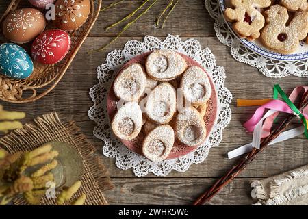Homemade Linzer cookies and Easter eggs decorated with wax on a table, top view Stock Photo