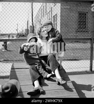 Mother with her two children at Lakeview nursery school for children of working mothers, operated by board of Education at tuition fee of three dollars weekly, Buffalo, New York, USA, Marjory Collins, U.S. Office of War Information, May 1942 Stock Photo
