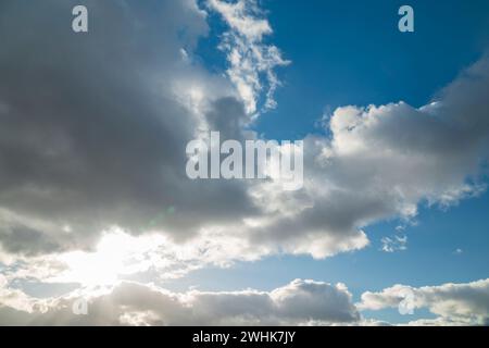 Blue sky background with sun shining through the clouds Stock Photo