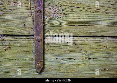 Rusty iron fitting on weathered greenish wood, vintage background texture with large copy space Stock Photo