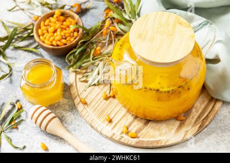 Healthy sea â€‹â€‹â€‹â€‹buckthorn tea with honey on a gray stone background. Autumn tea, berries seasonal drink. Stock Photo