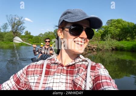 Man and woman couple, selfies are happy in family kayak trip rowing boat on the river, water hike, a summer adventure. Eco-frien Stock Photo