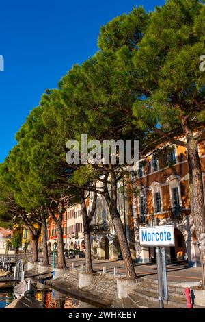 Old Beautiful Town with Building and Trees on the Waterfront on Lake Lugano with Boat in a Sunny Day in Morcote, Ticino, Switzerland Stock Photo