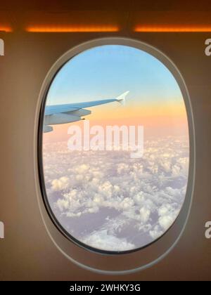 View from aeroplane window, porthole, Emirates airline, Airbus A380-800, sunset over the clouds, Dubai, United Arab Emirates, VAR Stock Photo