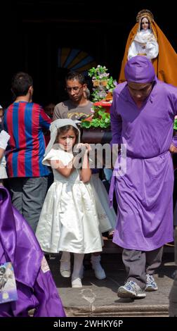 Antigua, Guatemala.  Semana Santa (Holy Week).  Young girls leaving the Cathedral of San Jose carrying an anda with the Virgin Mary. Stock Photo