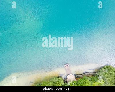 Aerial view of wooden pier leading to the sand lake with clear water. Lake with transparent water and popular tourist attraction Stock Photo