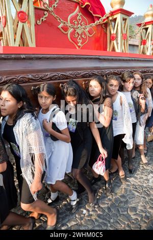 Antigua, Guatemala.  Semana Santa (Holy Week).  Young Girls Carrying an Anda (Float) of the Virgin Mary in a Religious Procession. Stock Photo