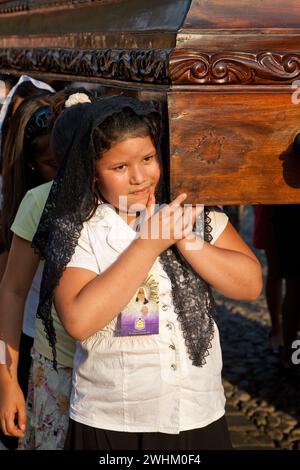 Antigua, Guatemala.  Semana Santa (Holy Week).  Young Girl Carrying an Anda (Float) of the Virgin Mary in a Religious Procession. Stock Photo