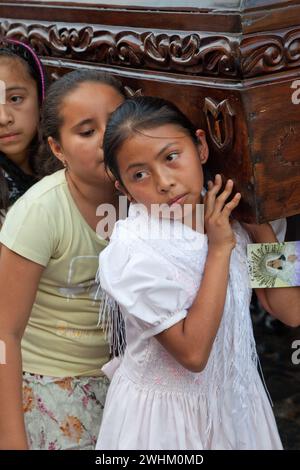 Antigua, Guatemala.  Semana Santa (Holy Week).  Young Girls Carrying an Anda (Float) of the Virgin Mary in a Religious Procession. Stock Photo