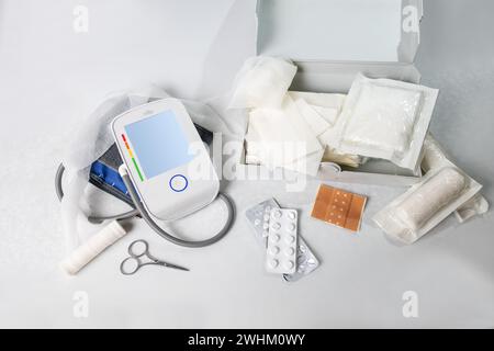 Medical supplies for first aid and the home medicine chest like blood pressure gauge, bandages, plasters, pills and scissors, li Stock Photo