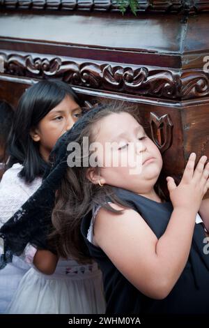 Antigua, Guatemala.  Semana Santa (Holy Week).  Young Girls Carrying an Anda (Float) of the Virgin Mary in a Religious Procession. Stock Photo